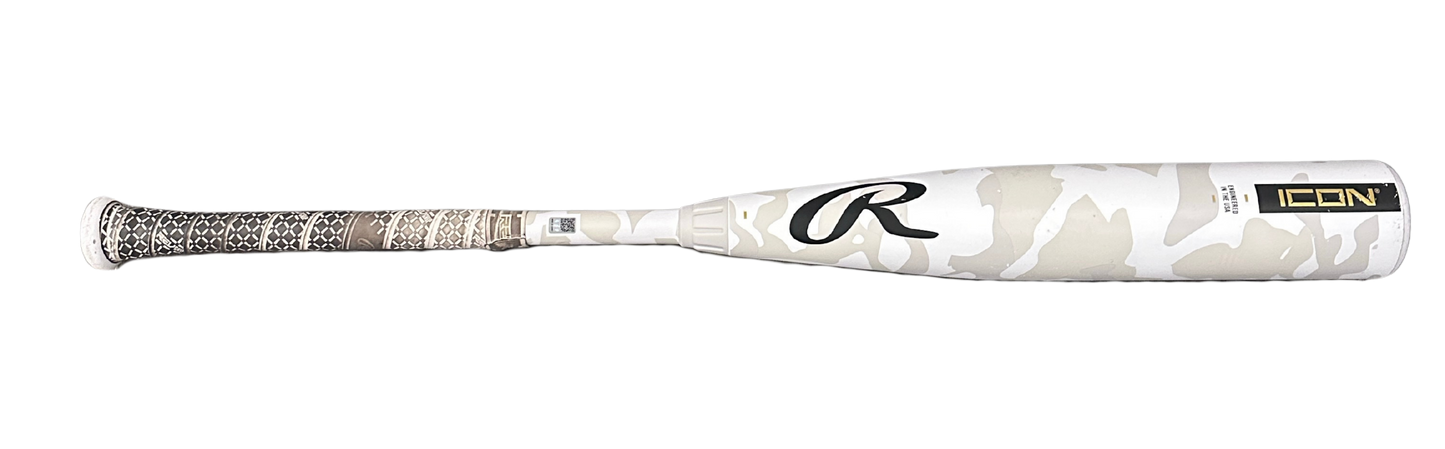A Rawlings Icon baseball bat featuring a white and beige camouflage pattern on the barrel, a textured black and white grip, and a gold and black Icon logo near the end.